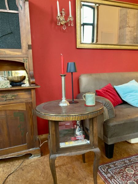 Sofa und Beistelltisch vor einer roten Wand.